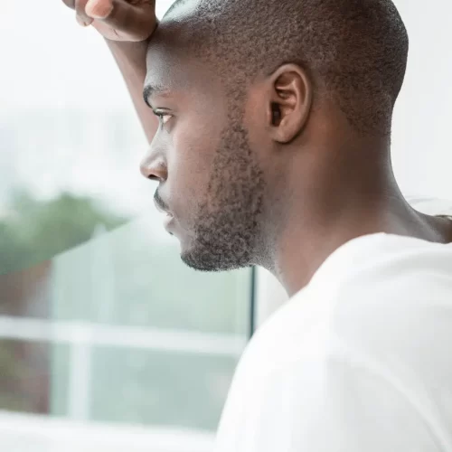 Man struggling with worry and anxiety looking out window